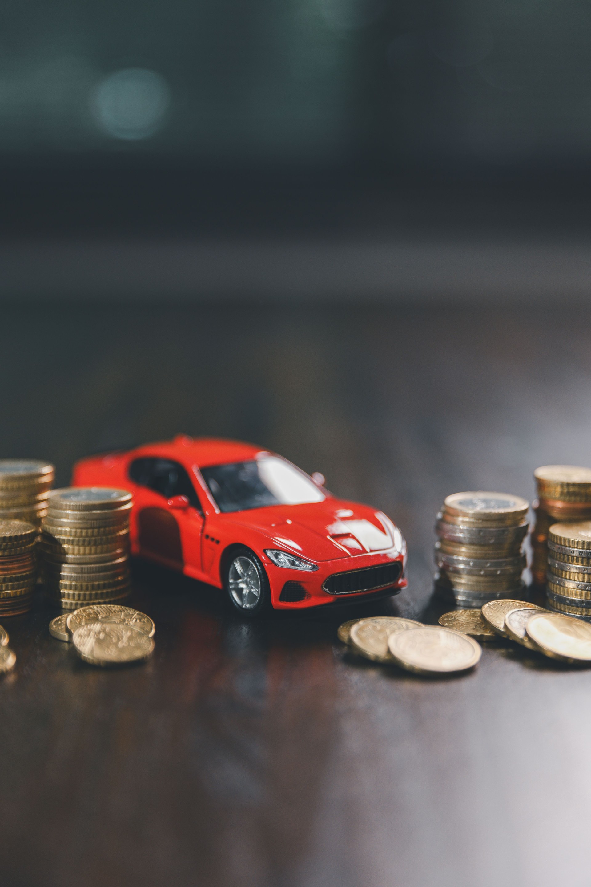 Euro car finance. car with calculator and money on wood table. insurance concept. investment and wealth accumulation through the symbolism of miniature car alongside coins.